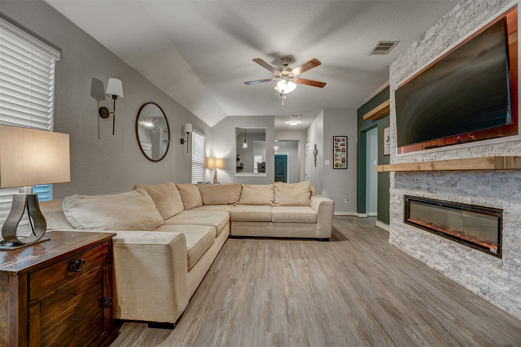 5806 Aviano Road Round Rock, TX 78665 - Photo 11 of 29 Warm wood-look flooring connects this spacious living area with a stone-clad fireplace feature.