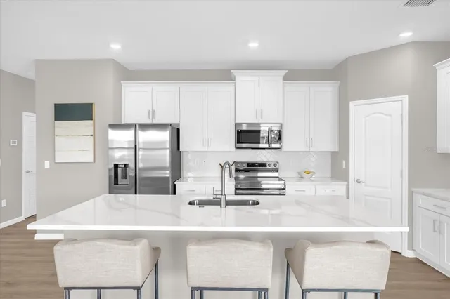 a kitchen with stainless steel appliances kitchen island granite countertop a sink and cabinets
