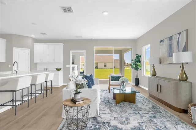 a living room with furniture and a dining table with wooden floor