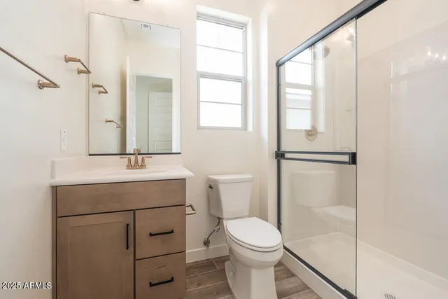 a bathroom with a toilet sink vanity and mirror
