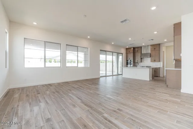 a view of a kitchen with wooden floor and windows