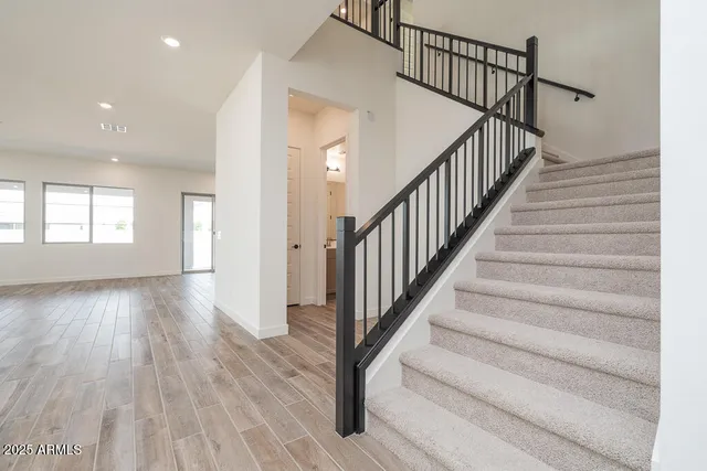 a view of staircase with wooden floor and white walls