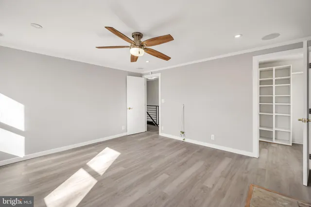 a view of empty room with wooden floor and window