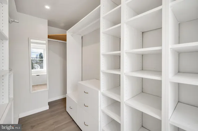 a room with white cabinets and wooden floors