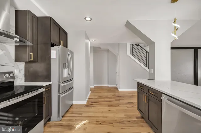 a kitchen with stainless steel appliances granite countertop a refrigerator and a stove