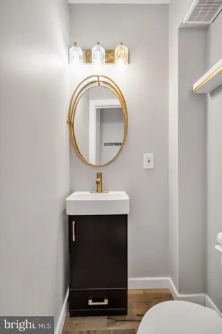 a bathroom with a sink a toilet and a mirror
