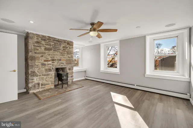 an empty room with windows and fireplace