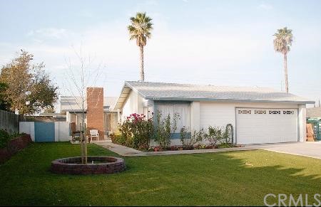 a front view of a house with a garden and plants