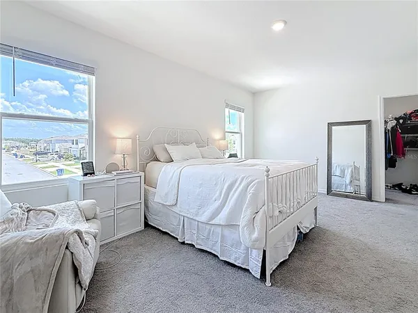 a spacious bedroom with a bed and a cabinets