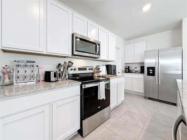 a kitchen with granite countertop white cabinets stainless steel appliances and sink