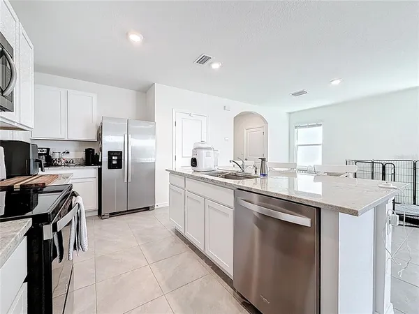 a kitchen with a sink a refrigerator and cabinets