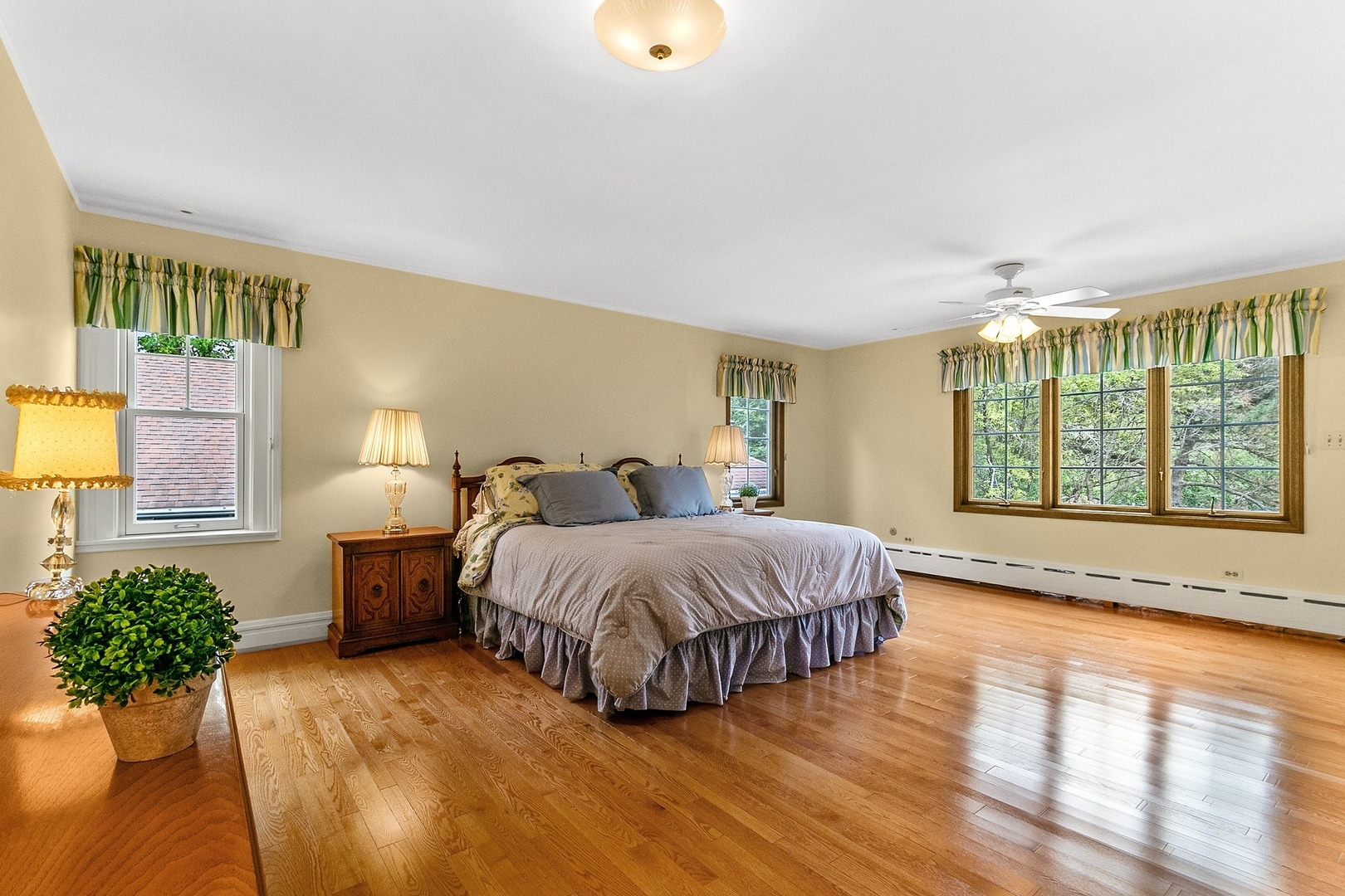 258 Southcote Road Riverside, IL 60546 - Photo 12 of 31 a spacious bedroom with a bed lamp and a large window with wooden floor