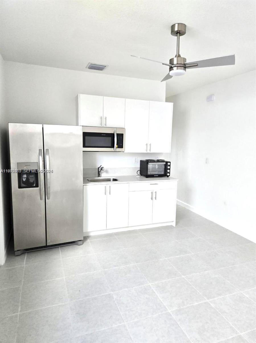14894 Southwest 163rd Street Miami, FL 33157 - Photo 13 of 15 a white kitchen with cabinets and a refrigerator