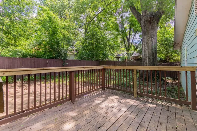a view of balcony with wooden floor and fence