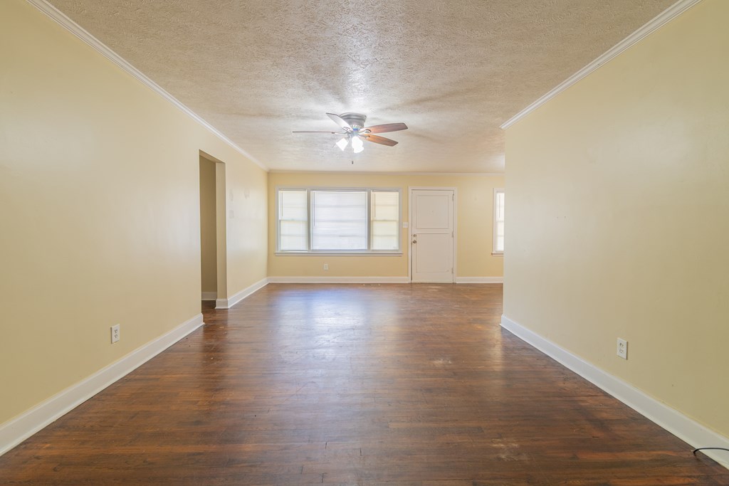 4214 17th Avenue Columbus, GA 31904 - Photo 4 of 15 an empty room with wooden floor and windows