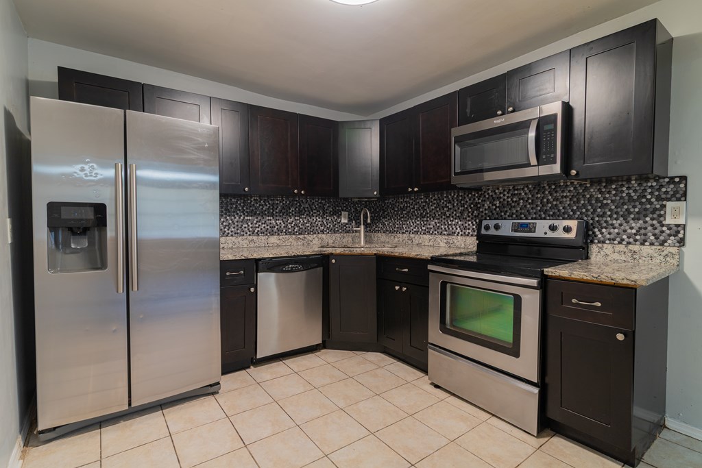 4214 17th Avenue Columbus, GA 31904 - Photo 6 of 15 a kitchen with stainless steel appliances granite countertop a refrigerator and a stove top oven