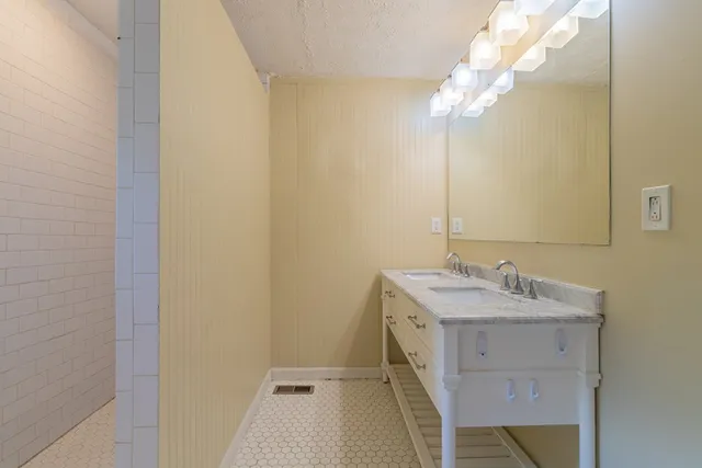 a bathroom with a sink vanity and a mirror