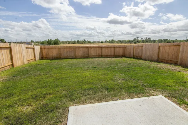 a view of a yard with a wooden fence