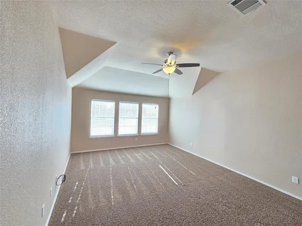 an empty room with windows and fan
