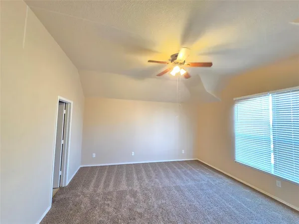 an empty room with a window and a fan