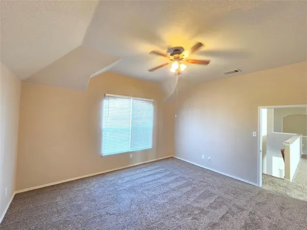 an empty room with windows and fan