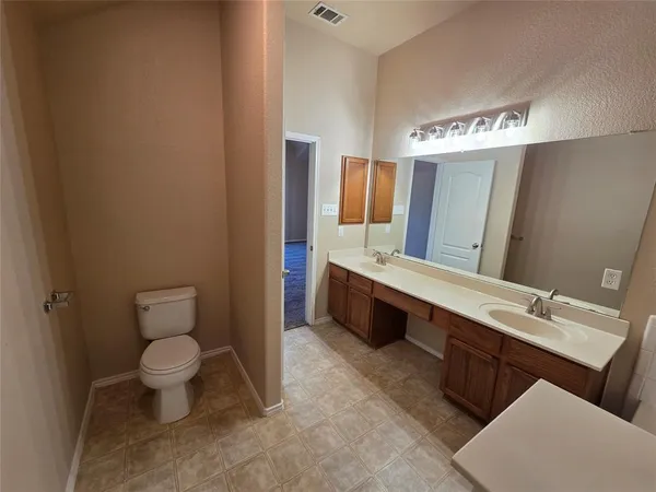 a spacious bathroom with a toilet sink and mirror