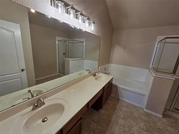 a bathroom with a tub sink and mirror