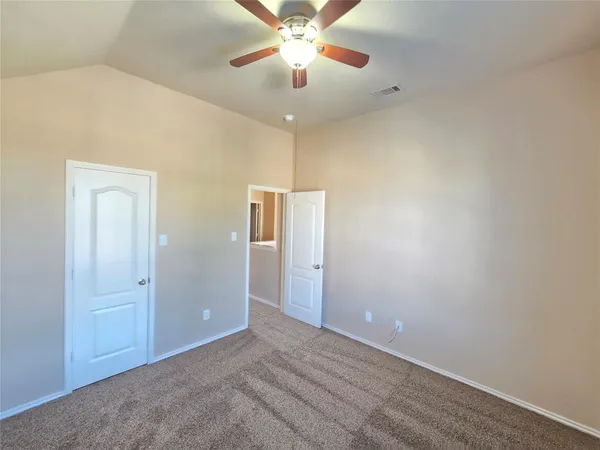 an empty room with closet and a chandelier fan