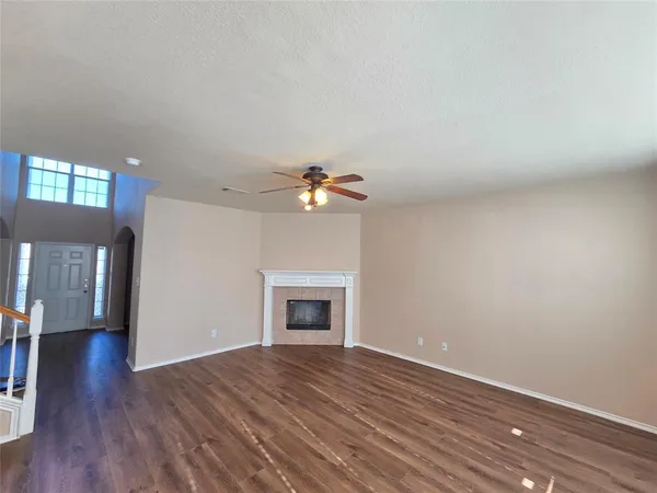 a view of empty room with wooden floor and fireplace