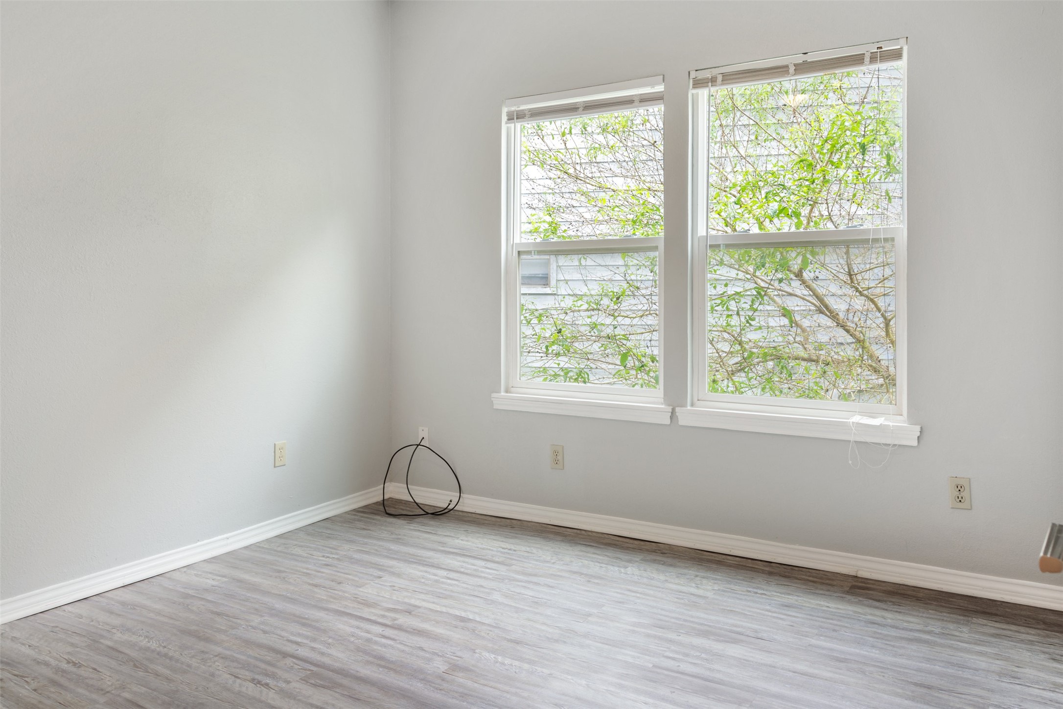 5303 Indio Cove, Unit A Austin, TX 78745 - Photo 10 of 15 an empty room with wooden floor and windows