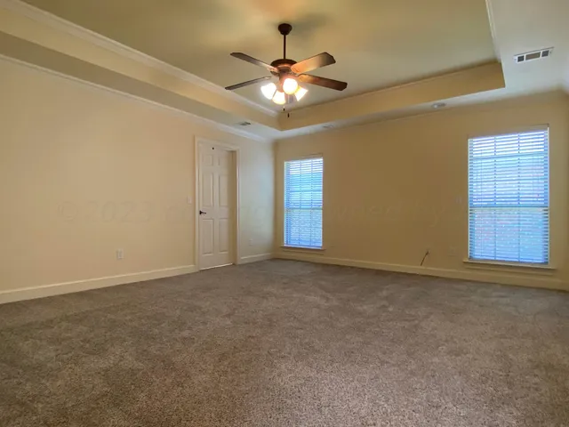a view of an empty room with a chandelier fan