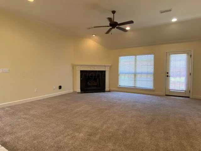 a view of an empty room with a fireplace and a window