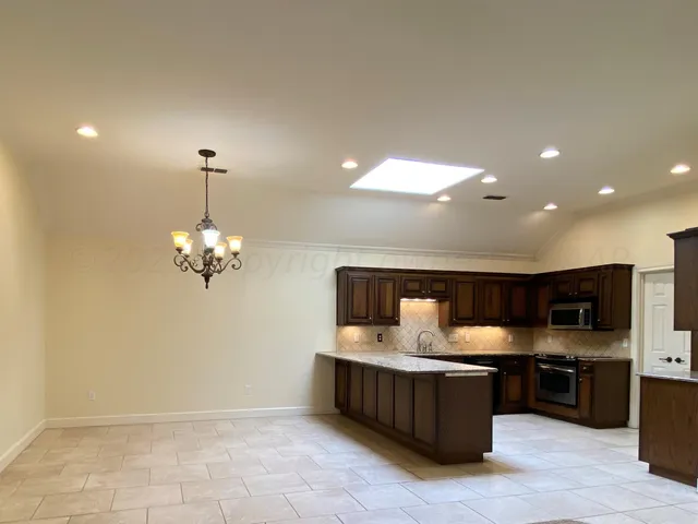 a living room with stainless steel appliances kitchen island granite countertop furniture wooden floor and a view of kitchen