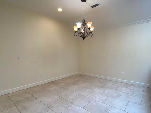 a view of a big room with a chandelier fan and windows