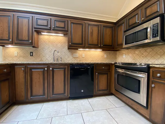 a kitchen with granite countertop wooden cabinets and stainless steel appliances