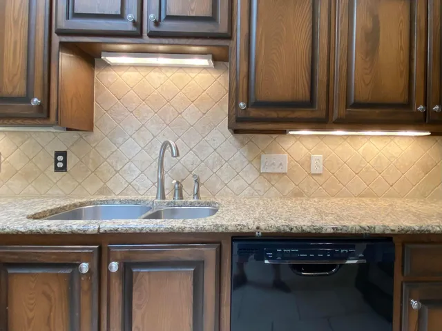 a kitchen with granite countertop a sink and cabinets