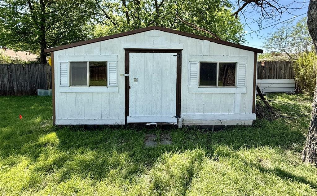 1114 Davis Street Cleburne, TX 76033 - Photo 13 of 17 a view of a small house with a yard