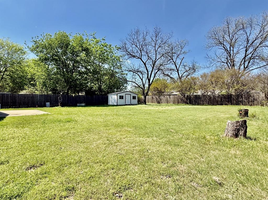1114 Davis Street Cleburne, TX 76033 - Photo 17 of 17 a view of swimming pool with a garden and trees