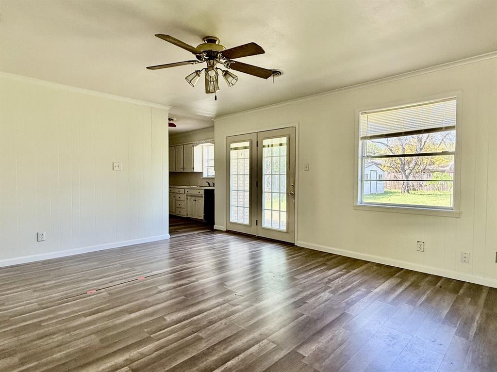 1114 Davis Street Cleburne, TX 76033 - Photo 3 of 17 an empty room with wooden floor and windows