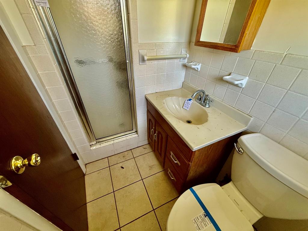 1114 Davis Street Cleburne, TX 76033 - Photo 8 of 17 a bathroom with a sink mirror vanity and toilet