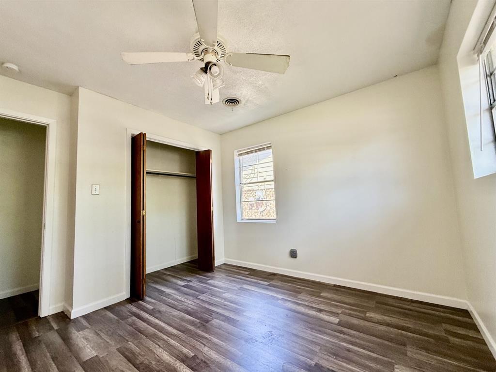 1114 Davis Street Cleburne, TX 76033 - Photo 9 of 17 a view of an empty room with wooden floor and a window