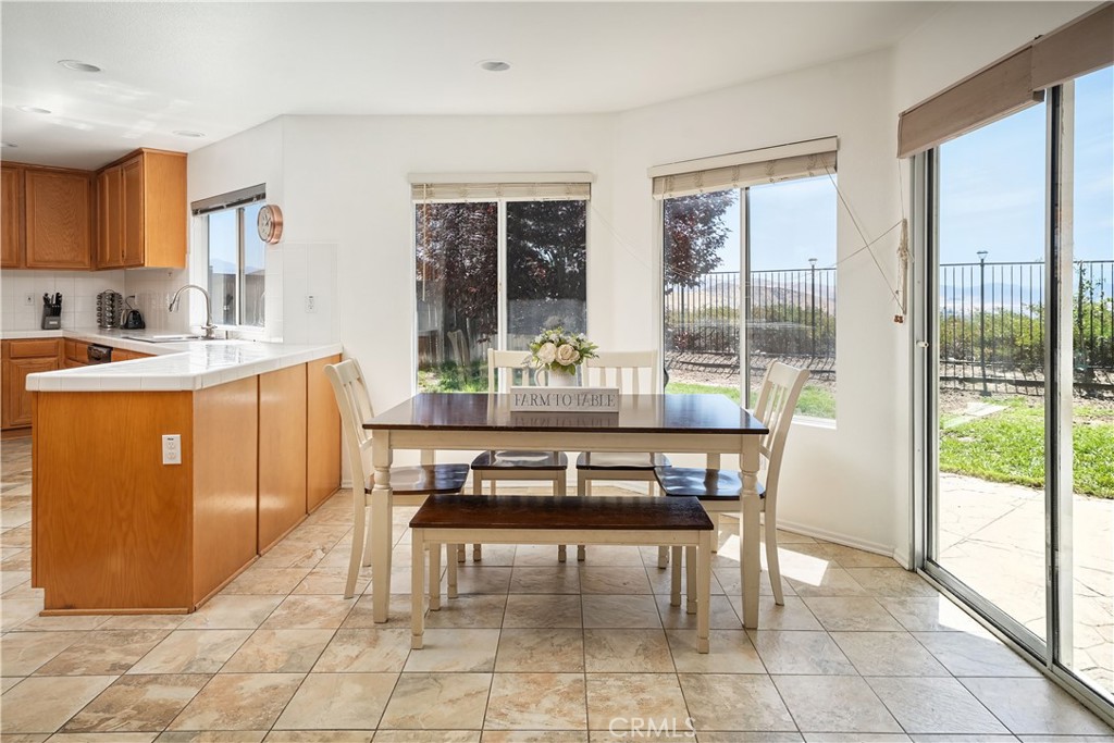 32610 Ridge Top Lane Castaic, CA 91384 - Photo 16 of 47 a dining room with stainless steel appliances granite countertop a stove a table and chairs next to a window