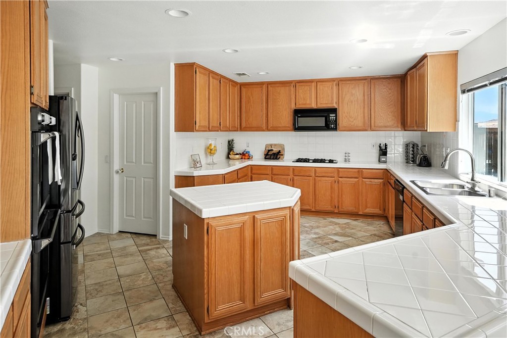 32610 Ridge Top Lane Castaic, CA 91384 - Photo 18 of 47 a kitchen with stainless steel appliances granite countertop a sink a stove and a refrigerator