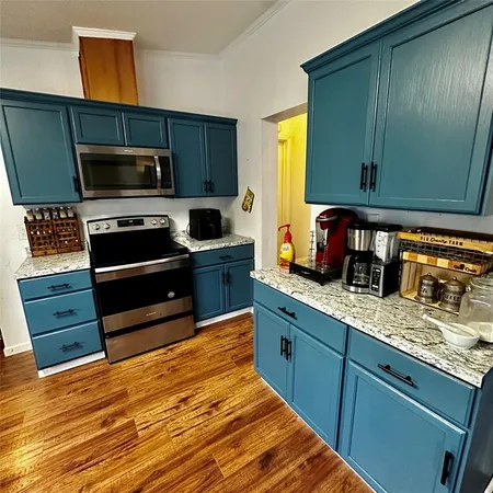 a kitchen with stainless steel appliances granite countertop a stove a sink and a microwave