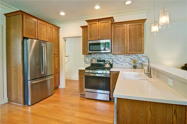 a kitchen with stainless steel appliances granite countertop a refrigerator stove and sink