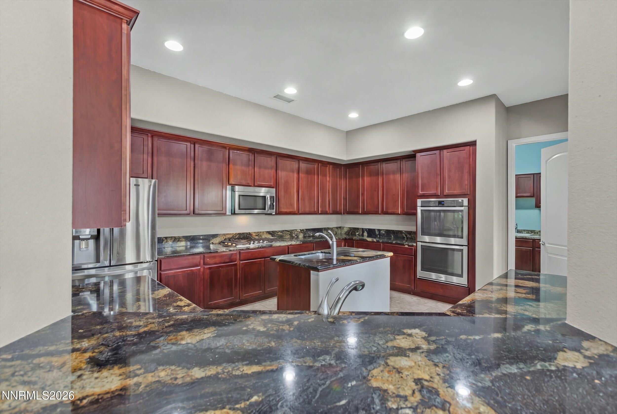 2920 Bull Rider Drive Reno, NV 89521 - Photo 10 of 51 a kitchen with stainless steel appliances granite countertop a refrigerator sink and stove