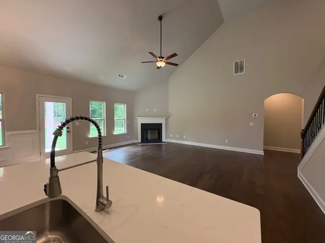 a view of a livingroom with a piano and wooden floor