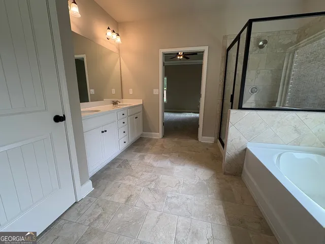 a bathroom with a tub sink and mirror