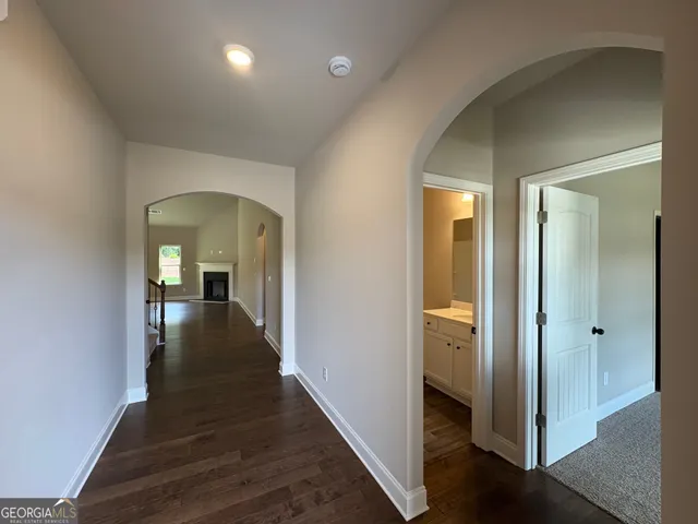 a view of a hallway with wooden floor and closet