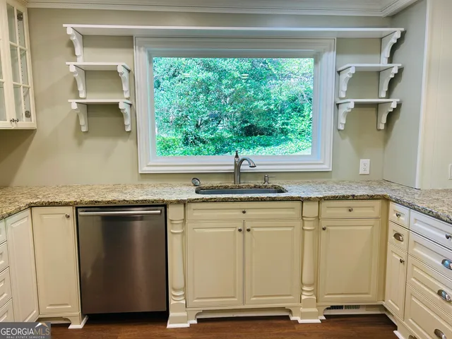 a kitchen with a stove oven and a wooden floor